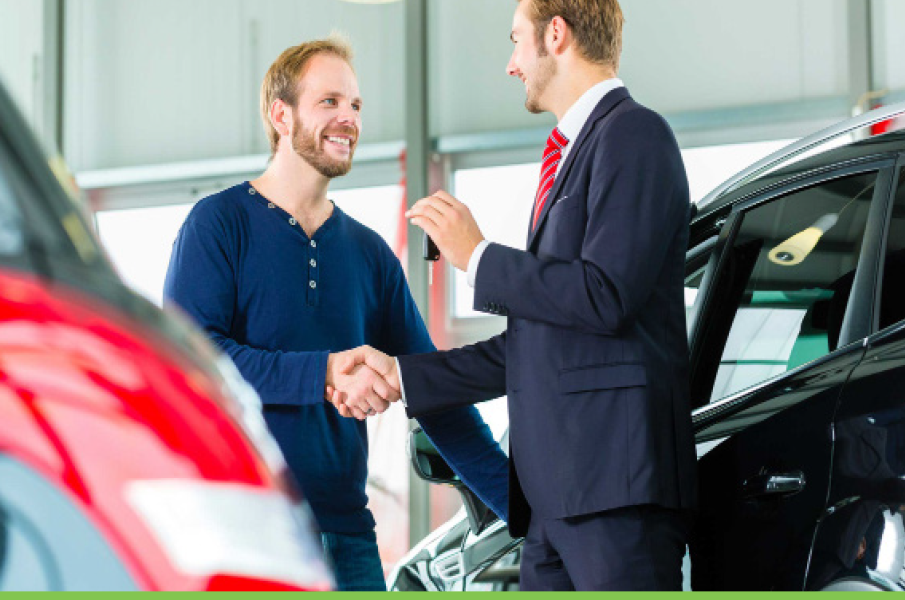 Car salesmen handing keys to new car buyer